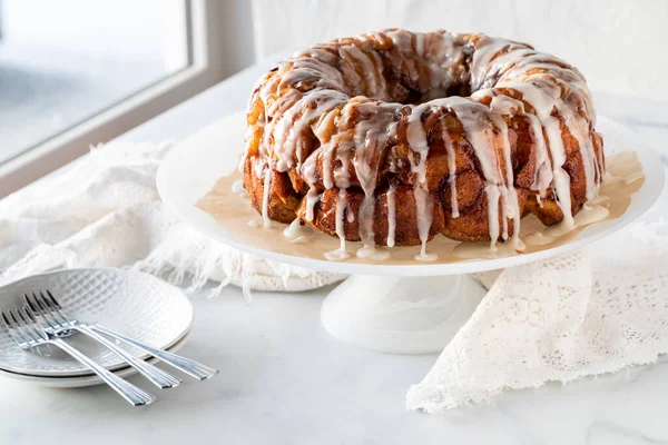 An apple cinnamon pull apart coffee cake drizzled with icing, ready for serving. — Zdjęcie stockowe