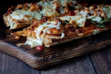 Ahşap bir tahtanın üzerinde koyu renk bir arka planda kızarmış pizza ekmeği..