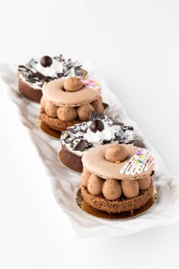 Beyaz arka planda bir sıra gurme pasta görüntüsünü kapat.