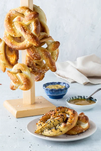 Homemade baked pretzels served with mustard dip and a tower of them in behind. — Stock Photo, Image
