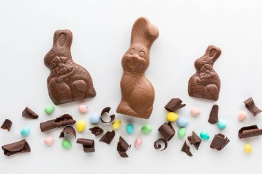 Çikolatalı Paskalya tavşanları. Altında çikolata parçacıkları ve yumurtalar var..