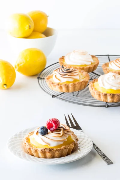 Una porzione di torta di meringa al limone fatta in casa guarnita con frutti di bosco freschi. — Foto Stock