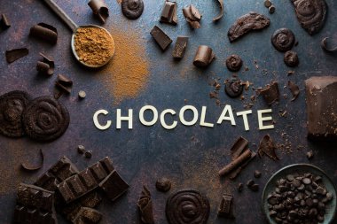 Çeşitli çikolata parçalarının, kurabiyelerin ve talaşların düzenlenmesi. Çikolata konsepti