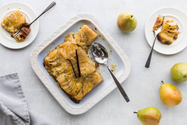 Vanilya kabukları ve kekik ile süslenmiş lezzetli armut baş aşağı kek..