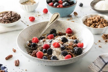 Bir kase yulaf yoğurdunun, meyvelerin, fındıkların ve tohumların içine bakmak..