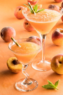 Şeftaliyle çevrili iki şeftalili Bellini şeftali arka planda.