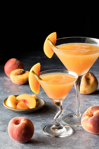 Şeftali dilimleriyle süslenmiş iki şeftali rengi Bellini..