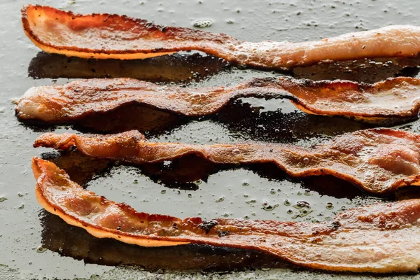 Fritando bacon Sizzling em uma frigideira. — Fotografia de Stock