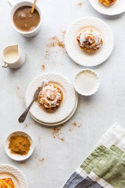 Tabaklarda taze tarçınlı çörekler ve kahve tabakları..