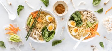 İçi malzemelerle çevrili Vietnam Pho çorbası kaseleri..