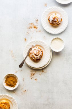 Krem peynirli tarçınlı ruloların üstünde..
