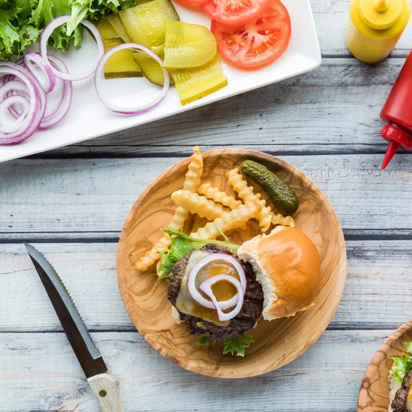 Patates kızartması ve bir tepsi soslu kaygan çizburgerin yukarıdan görünüşü.