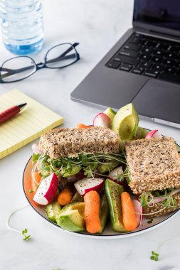 Sağlıklı bir pelerin tohumu taze kesilmiş çiğ sebzelerle servis edilen tahıllı sandviç..