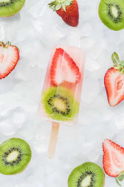 一个草莓猕猴桃冰上的冰棒被猕猴桃和草莓片包围着. — 图库照片