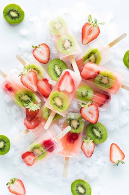 Dilimlenmiş çilek ve kivi dilimli taze çilekli dondurma yığını..