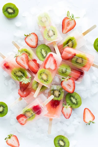 Dilimlenmiş çilek ve kivi dilimli taze çilekli dondurma yığını..