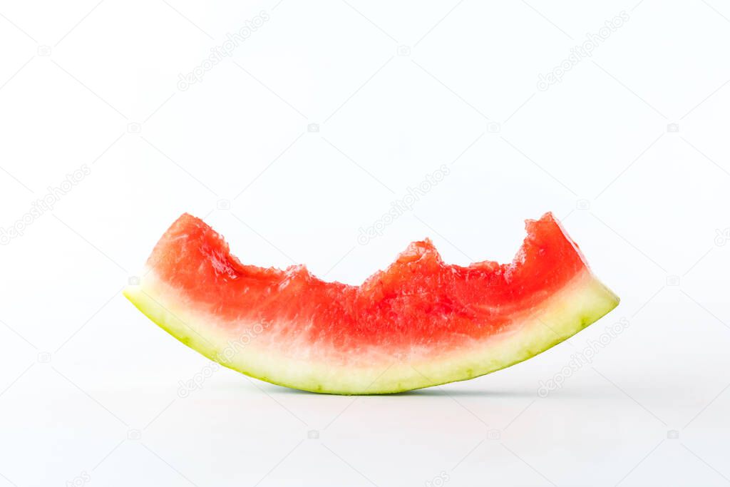 Close up of a mostly eaten juicy watermelon slice isolated against a white background. 