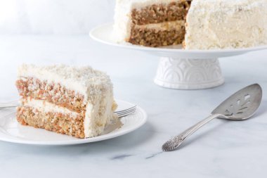 Beyaz, hindistan cevizli, havuçlu kek. Önünde de bir dilim yemeye hazır.. 