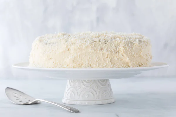 Een Witte Met Kokosnoot Bedekte Cake Tegen Een Lichte Ondergrond — Stockfoto