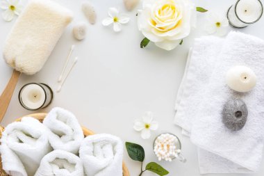 Yumuşak, zarif spa ögelerinin ortası beyaz, ortası fotokopi alanı olan bir düzeninin üstten aşağı görünümü.