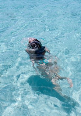 Young woman swimming in crystal clear tropical water