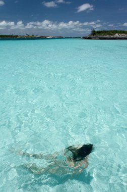 Young woman swimming in crystal clear tropical water