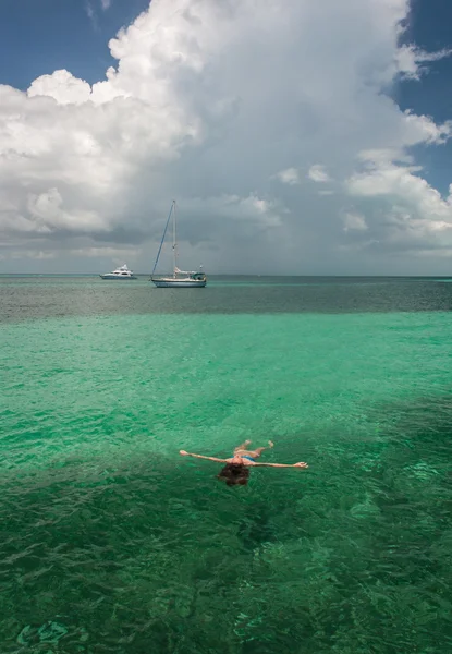 Woman floating in tropical waters — Stock Photo, Image