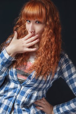 Kızıl saçlı kız sessizlik bir jest yapar