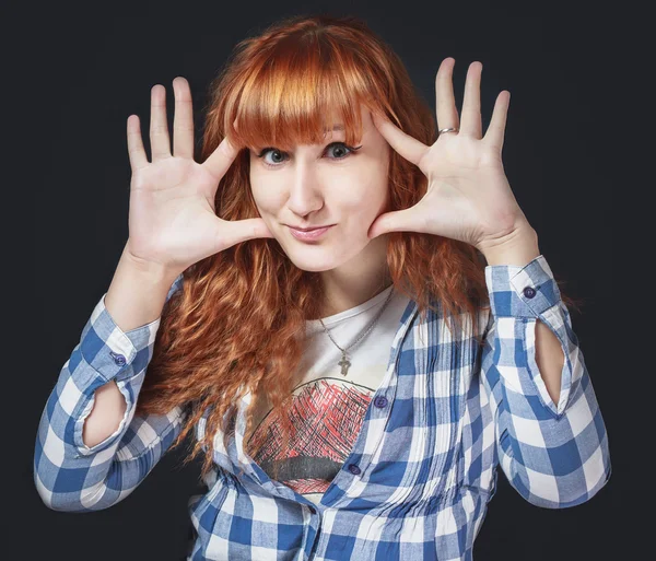 Red-haired girl shows emotion on a dark background — Stock Photo, Image