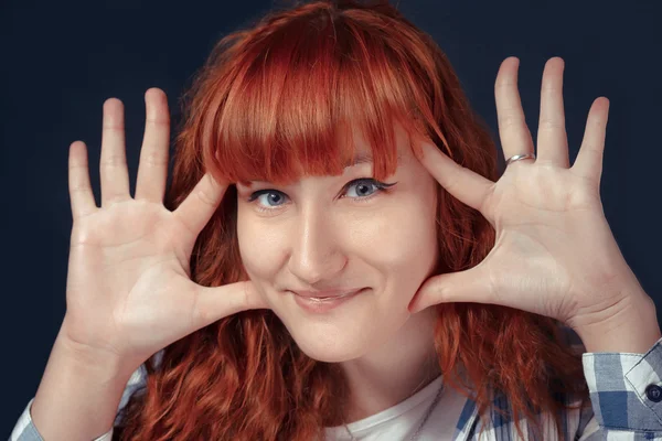 Red-haired girl shows emotion on a dark background — Stock Photo, Image