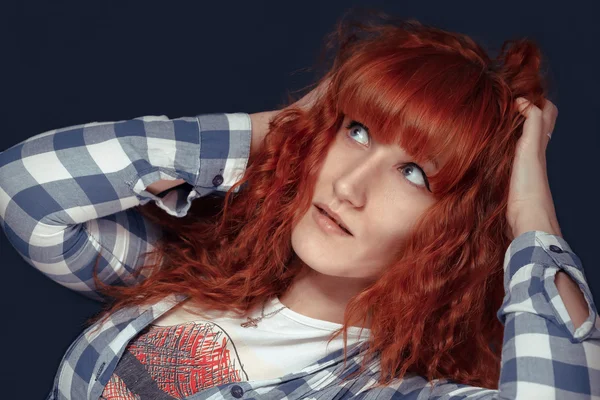 Ragazza dai capelli rossi mostra emozione su uno sfondo scuro — Foto Stock