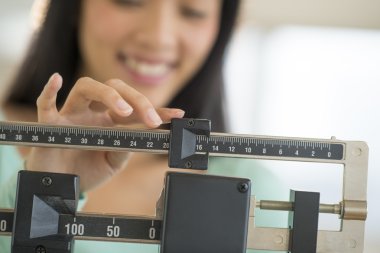 midsection ağırlık ölçek ayarlarken gülümseyen kadın