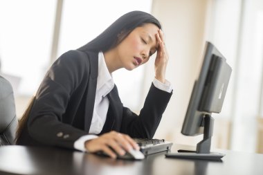 Masa başında bilgisayarla yorgun iş kadını