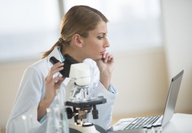 dizüstü bilgisayar laboratuvarında bakarak kadın bilim adamı