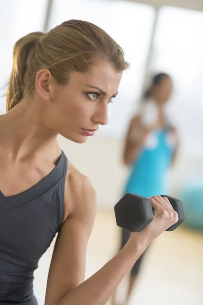 Mujer levantando pesas en el gimnasio — Foto de Stock