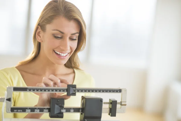 バランスのスケールで自身の重量を量る女性 — ストック写真