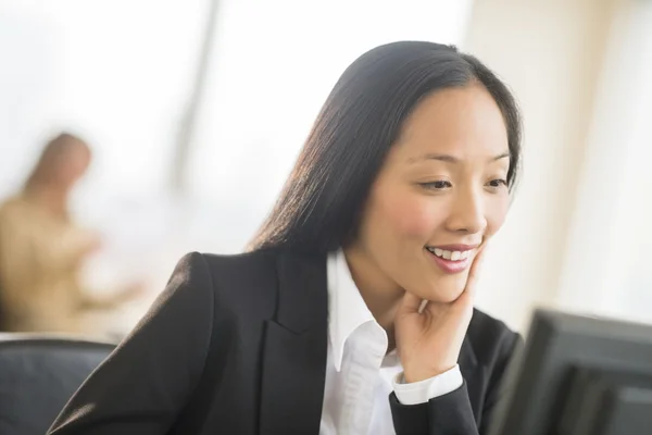 Feliz mujer de negocios mirando a la computadora en la oficina — Foto de Stock