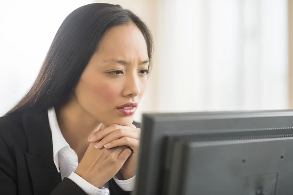 Geschäftsfrau schaut im Büro auf Computer — Stockfoto