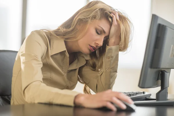 Mujer de negocios frustrada apoyada en el escritorio de la computadora — Foto de Stock