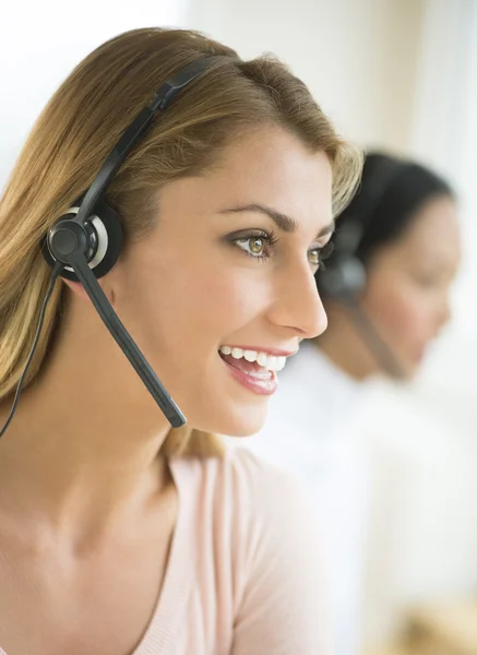 Zufriedene Kundendienstmitarbeiterin mit Headset — Stockfoto