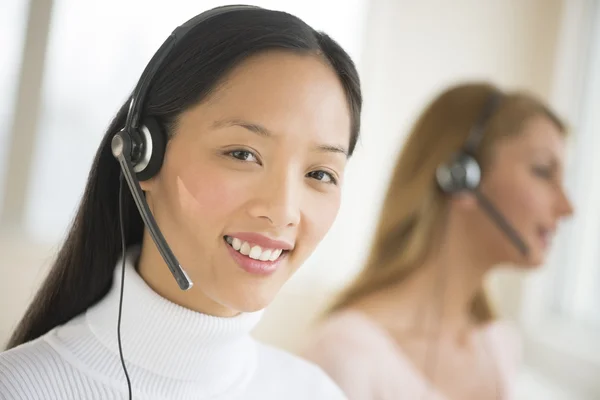 Portrait de représentante du service à la clientèle féminine souriant à de — Photo