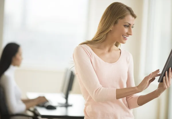 Glad affärskvinna med digital tablet i office — Stockfoto