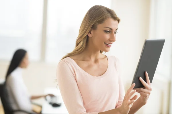 Glad affärskvinna tittar på touchpad i office — Stockfoto