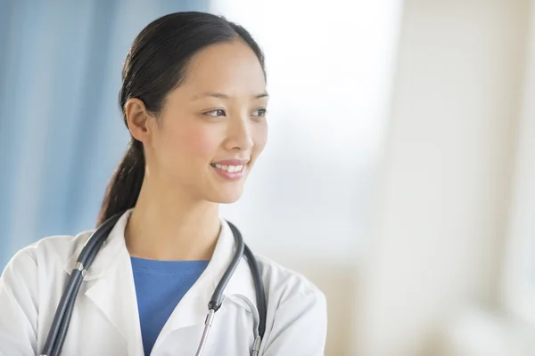 Medico femminile riflessivo guardando lontano — Foto Stock