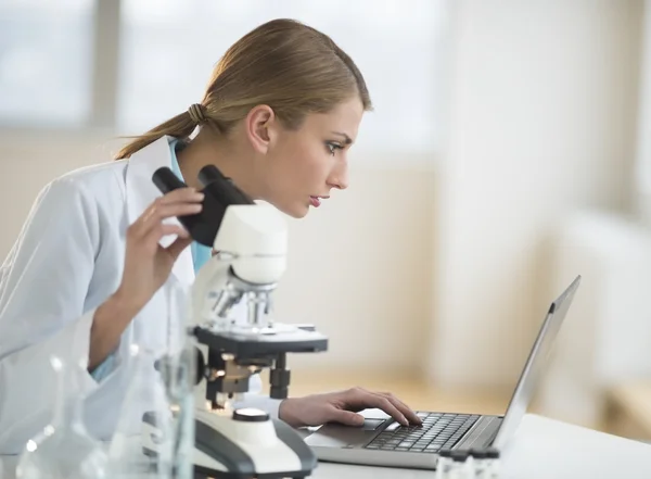 Scienziata femminile che utilizza il computer portatile alla scrivania in laboratorio — Foto Stock