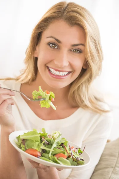 Mulher feliz comer salada de legumes — Fotografia de Stock