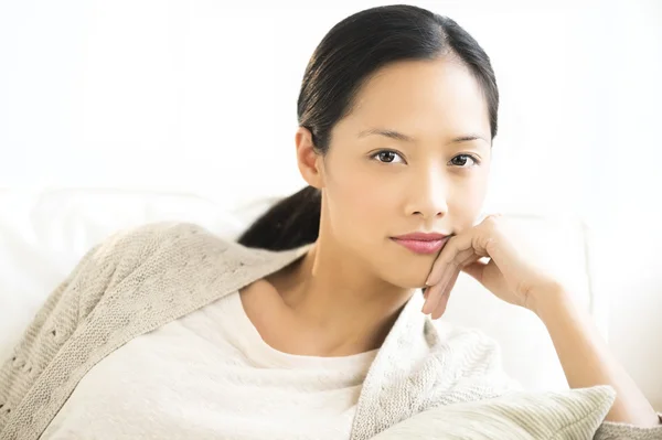 Retrato de mulher sorrindo enquanto relaxa no sofá — Fotografia de Stock