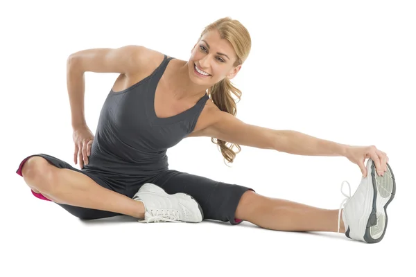 Schöne Frau streckt sich, um ihre Zehen zu berühren — Stockfoto