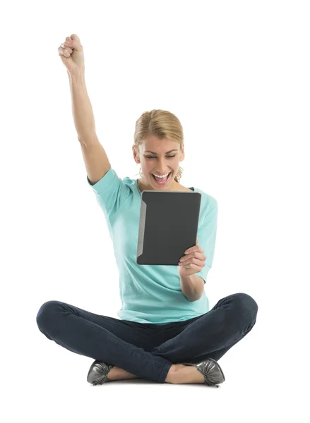 Podekscytowana kobieta z ręką uniesioną do góry za pomocą cyfrowego tabletu — Zdjęcie stockowe