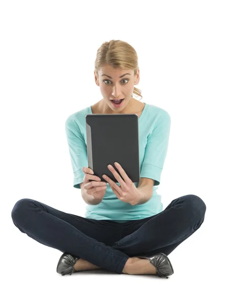 Mujer joven asombrada mirando la tableta digital — Foto de Stock